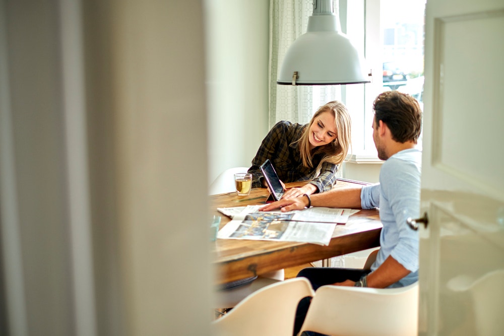 man en vrouw bekijken laptop aan tafel