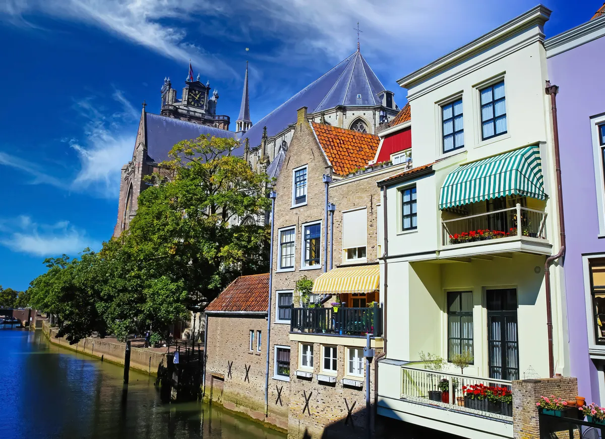 Vrolijk gekleurde appartementen aan een rivier met balkons en zonneschermen