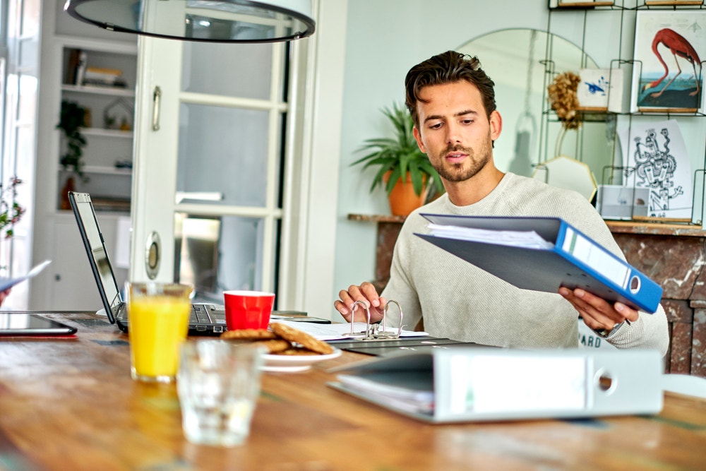 man aan tafel bekijkt map