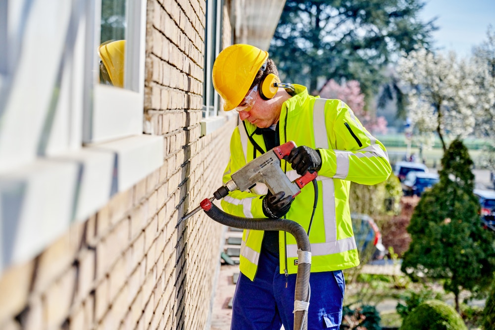 Man isoleert spouwmuur