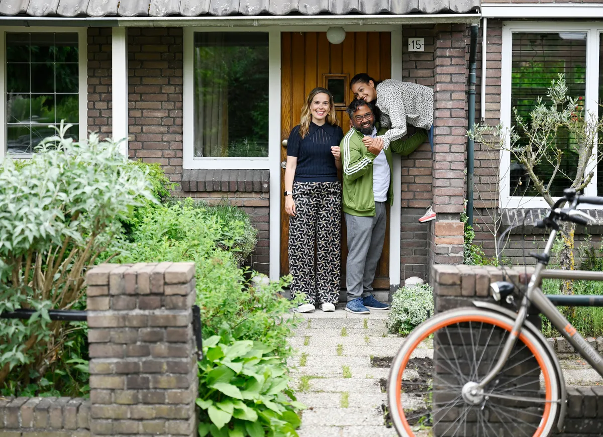 Gezin staat voor hun huis.