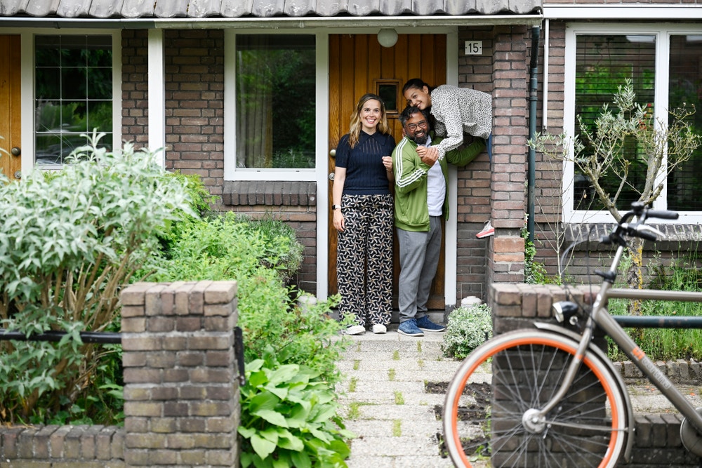 Gezin staat voor hun huis.