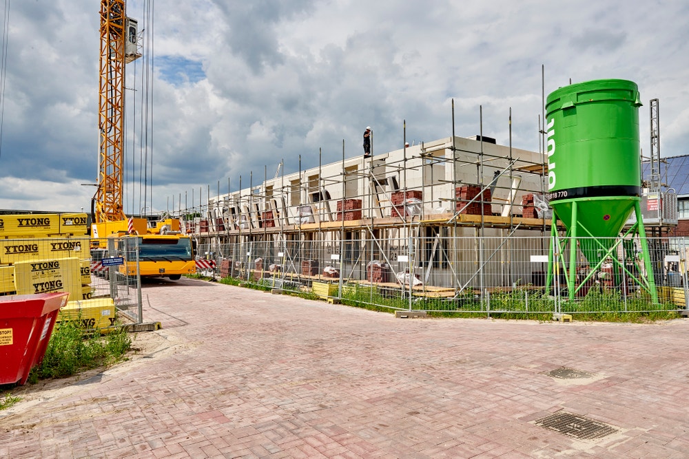 Hijskraan rijdt door straat van nieuwbouwwijk in aanbouw