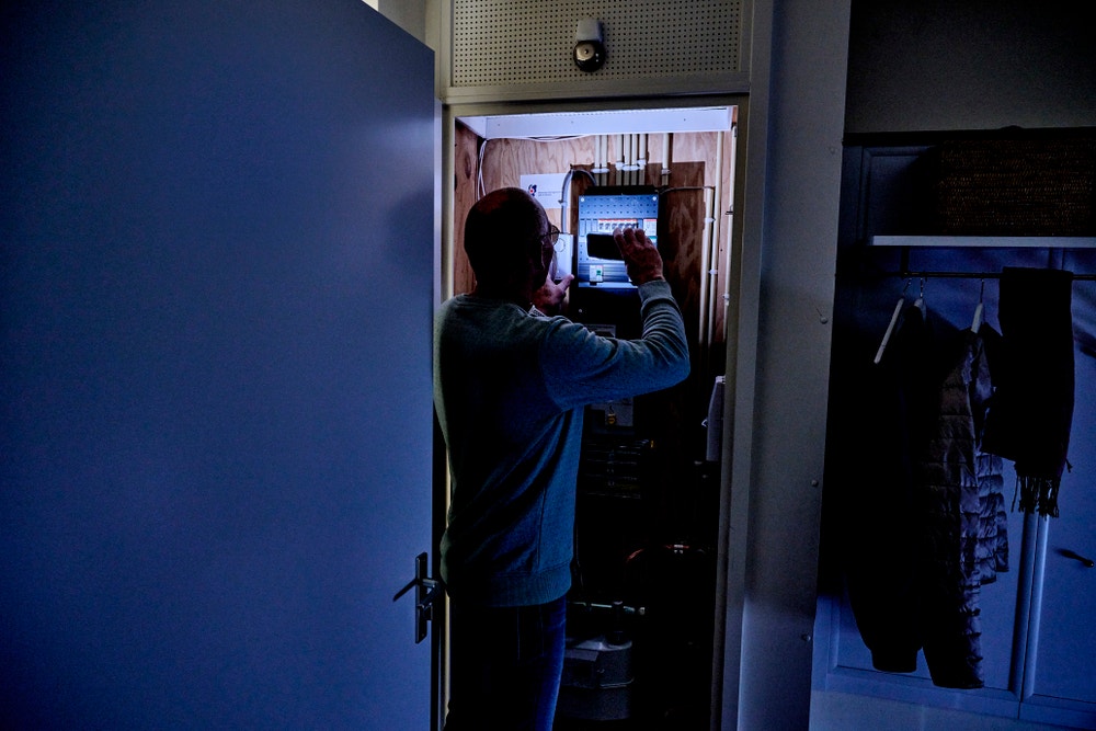 man controleert meterkast met zaklamp