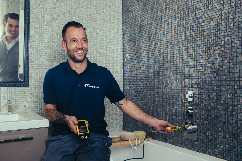 Man zit op bad en meet het vocht in de muur