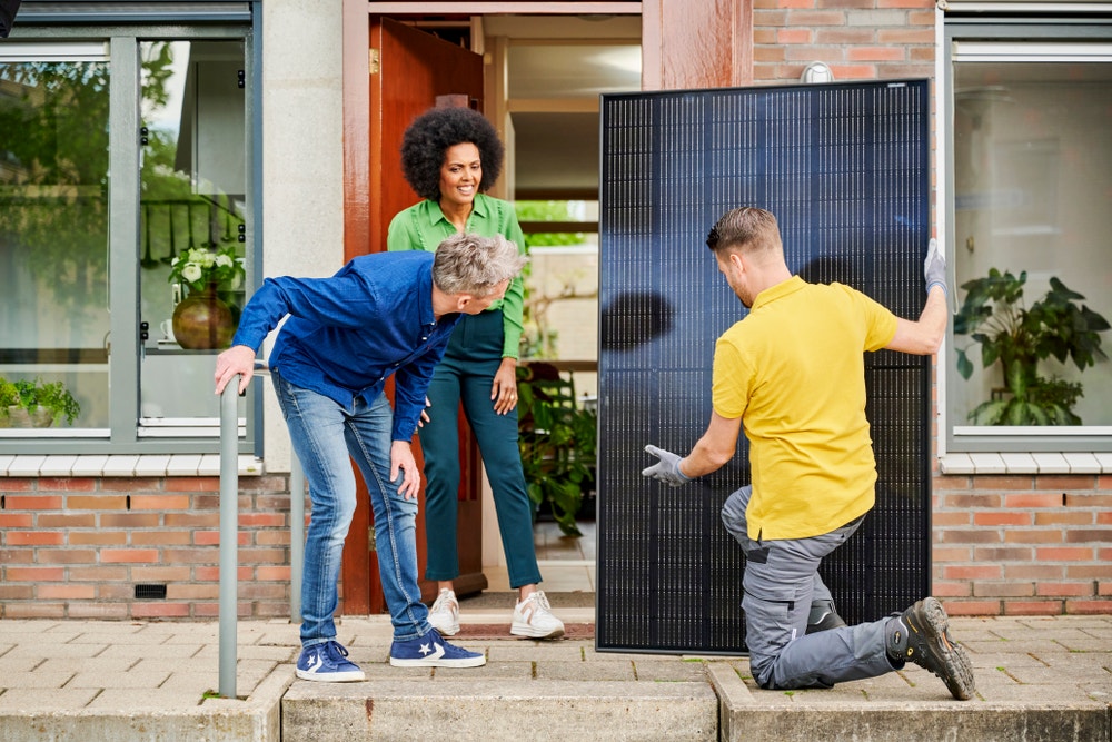 installateur met zonnepaneel en man en vrouw