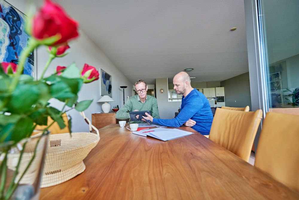 adviseur licht verduurzamingsadvies toe aan lid aan tafel