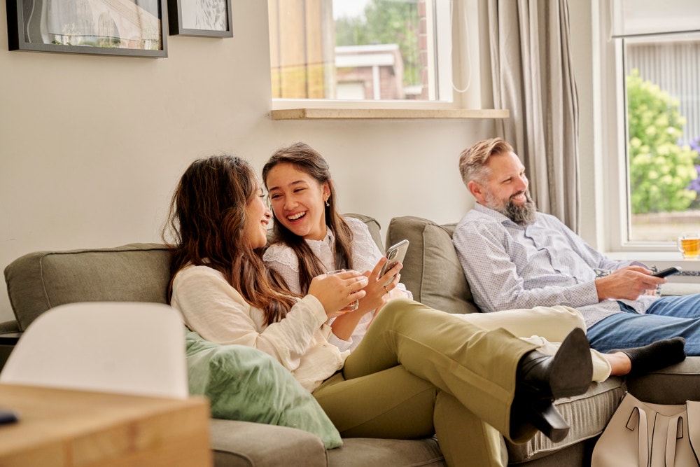 vrouwen en man lachend op bank