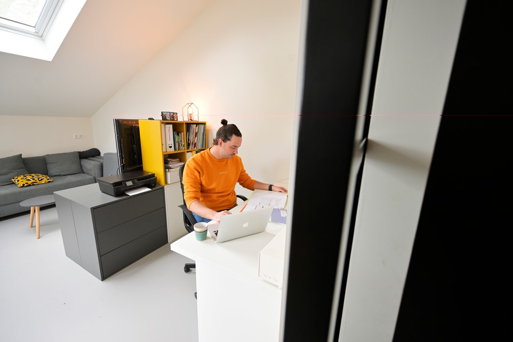 man zit achter laptop in kantoor met energiecontract