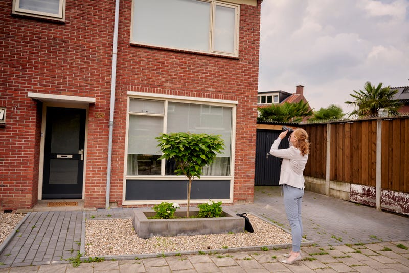 Vrouw fotografeert buitenkant huis