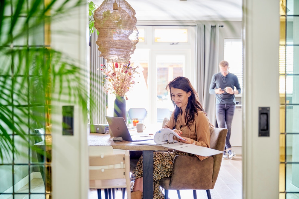 vrouw leest uit map aan tafel