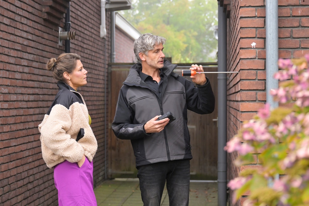 Adviseur meet gevel voor spouwmuurisolatie