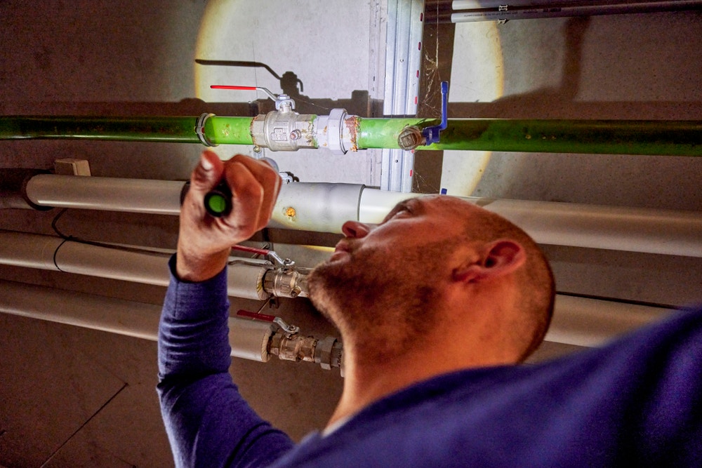 man in parkeergarage controleert gasleiding