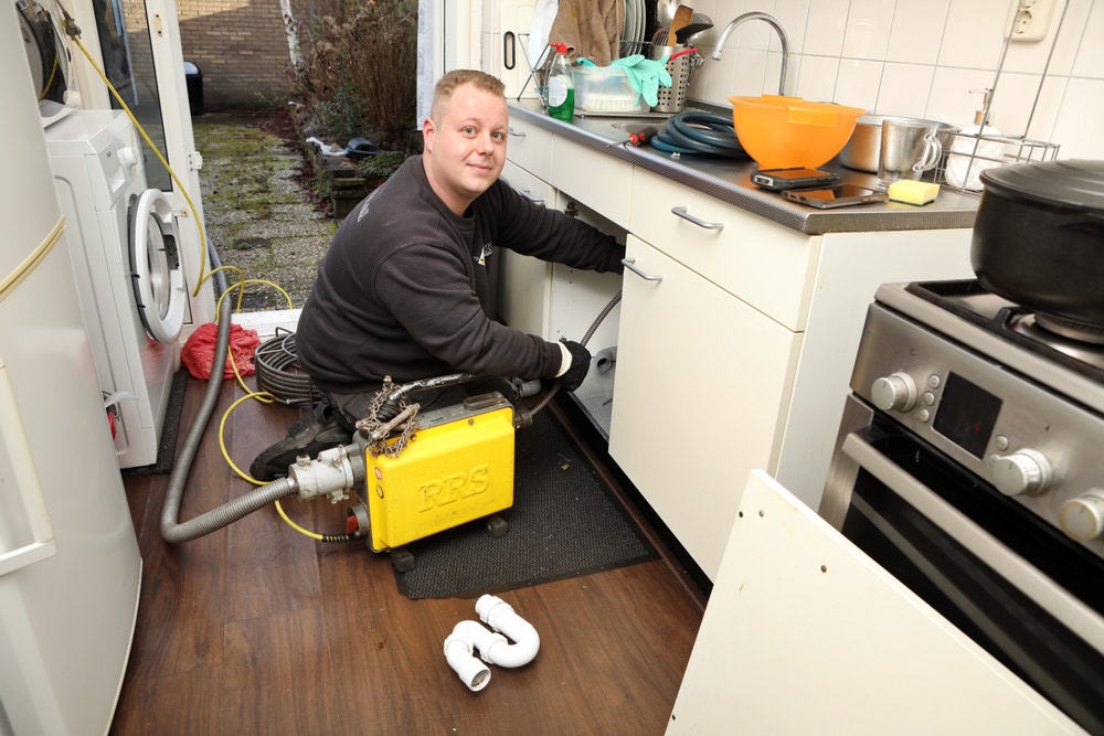 Ontstopper werkt in keukenkastje bij gootsteen