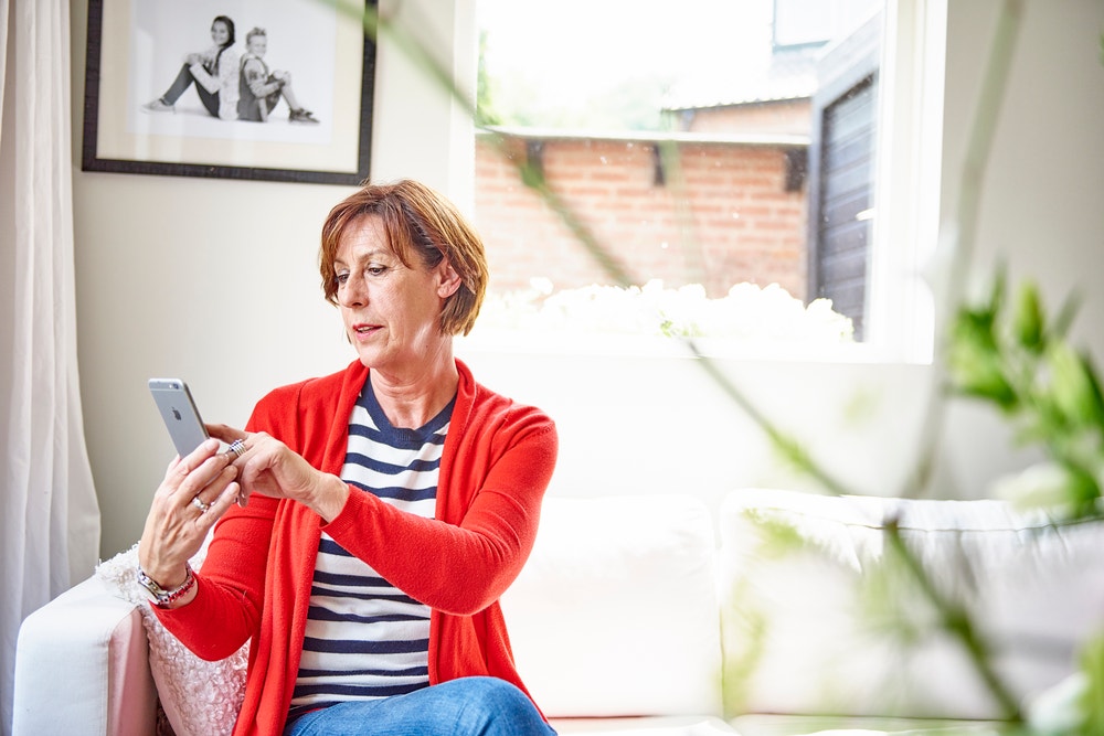 Mevrouw gebruikt de subsidiecheck op haar telefoon.