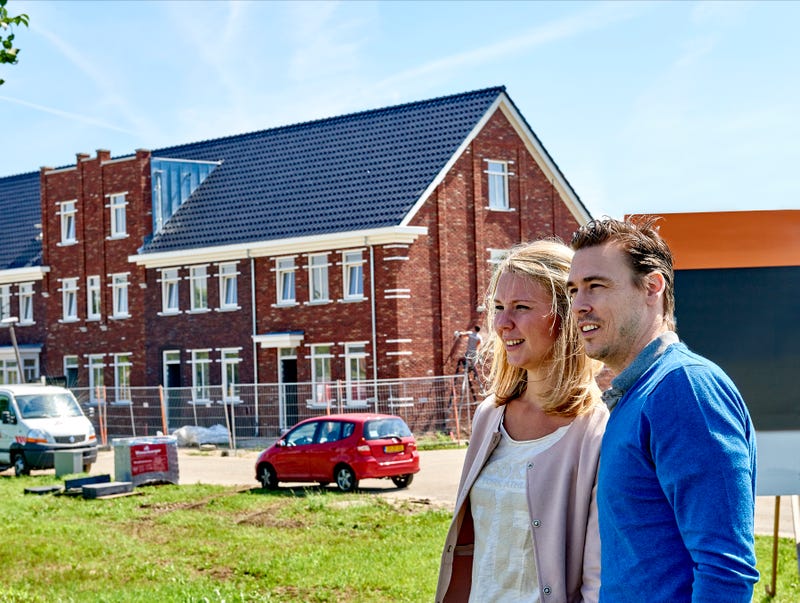 man en vrouw bekijken huizen in aanbouw