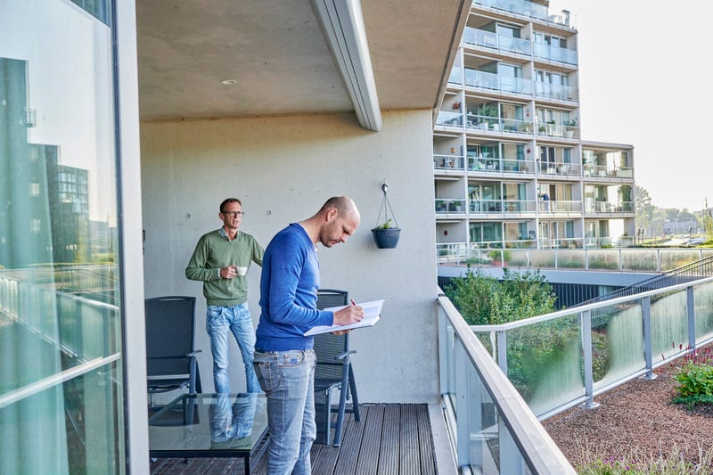 mannen bekijken papierwerk op balkon
