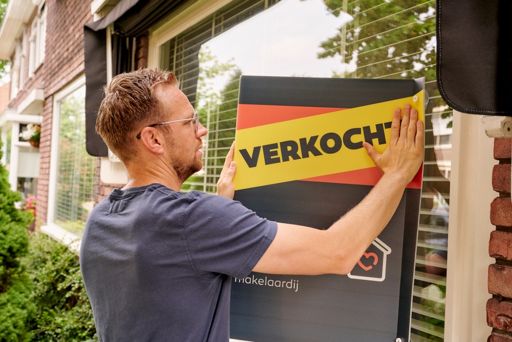 Man plakt huis verkocht op