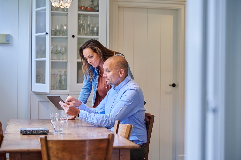 man en vrouw aan tafel met ipad