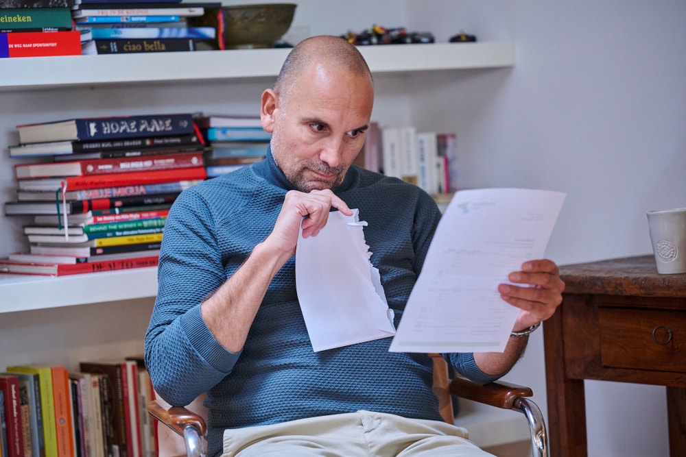 man kijkt naar papierwerk