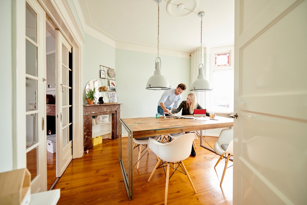 man en vrouw in woonkamer met krant en ipad