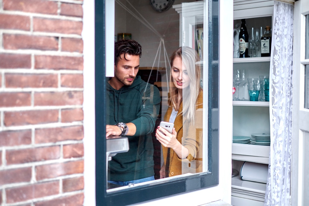 jong stel bij raam met telefoon