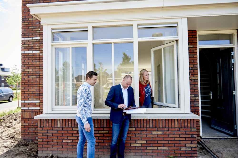 Bouwkundige keuring bij het raam drie mensen