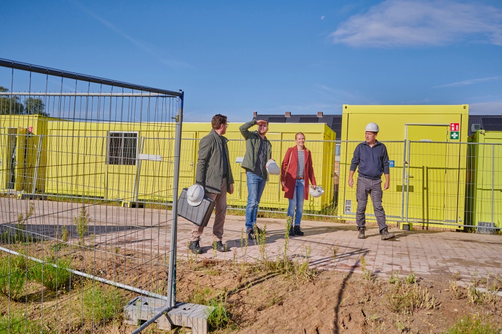 vier mensen bij bouwkeet