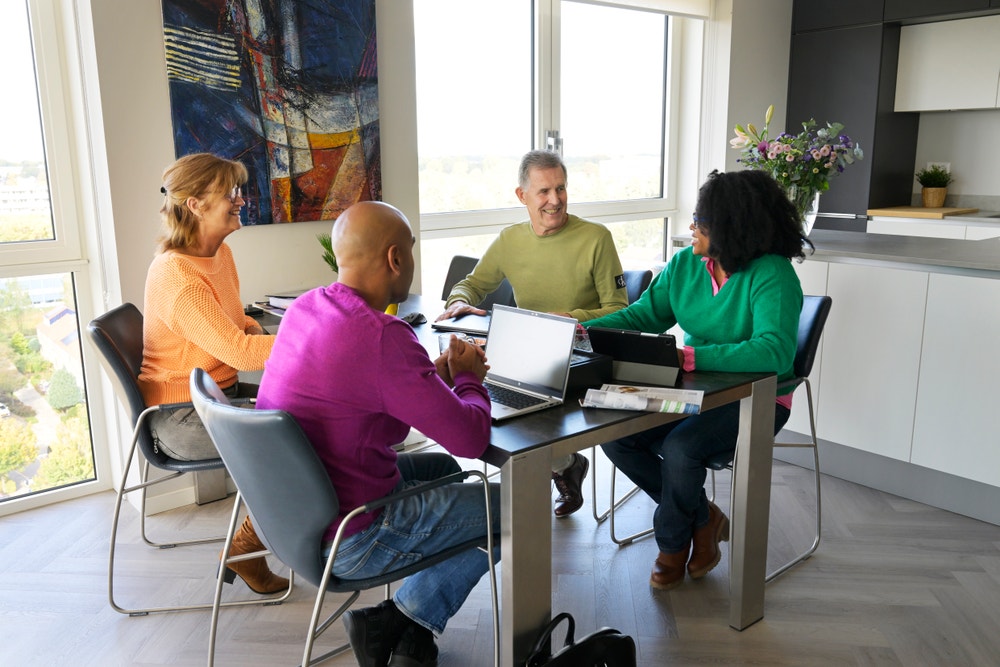 Mensen kijken en luisteren naar de VvE vergadering