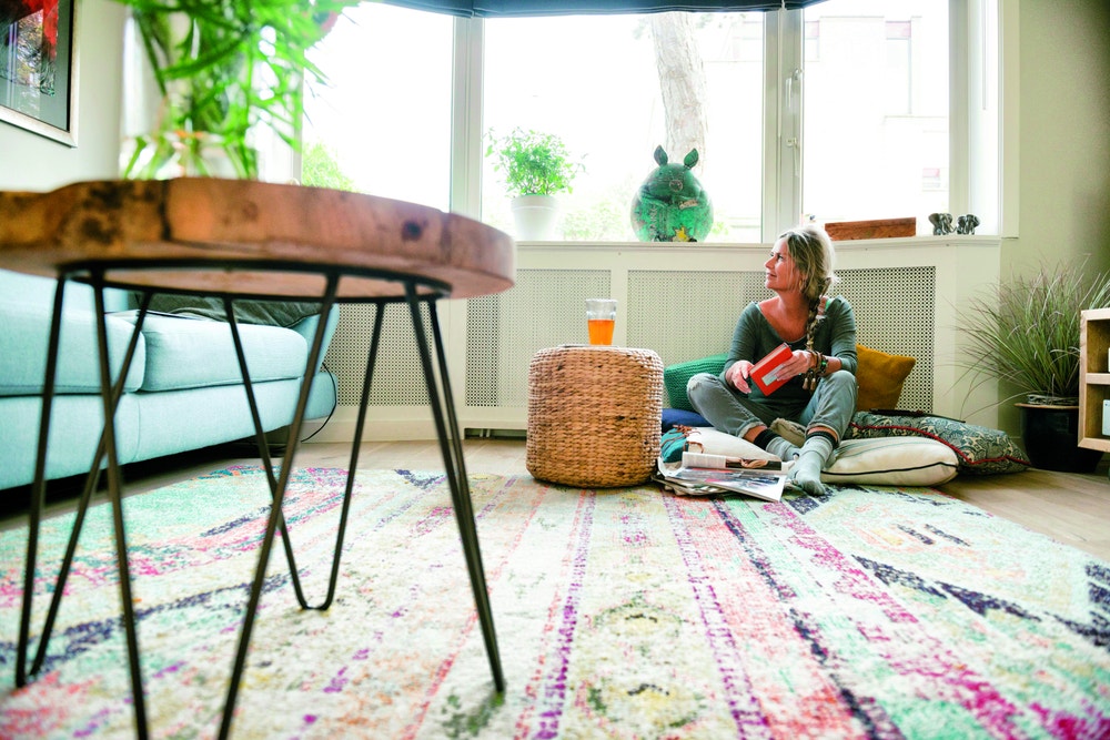 vrouw leest boek en zit tegen verwarming
