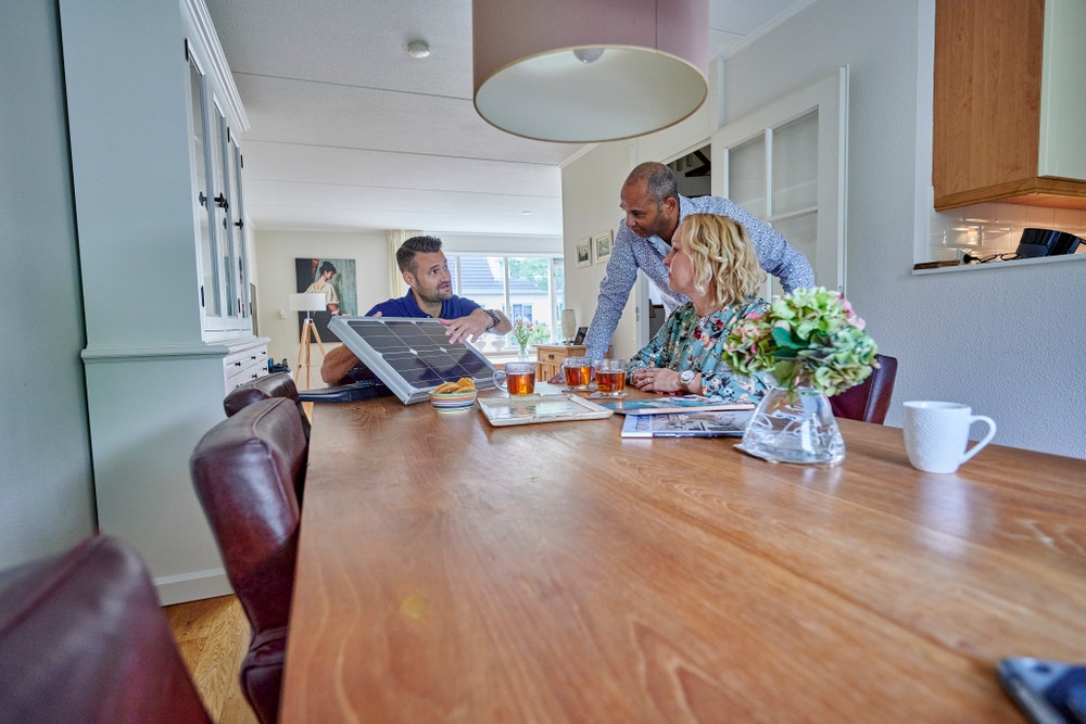 zonnepanelen adviseur geeft uitleg aan man en vrouw aan tafel
