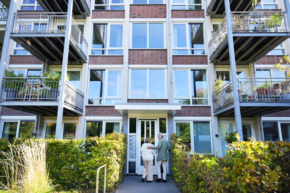 flatgebouw omgeven door heggen