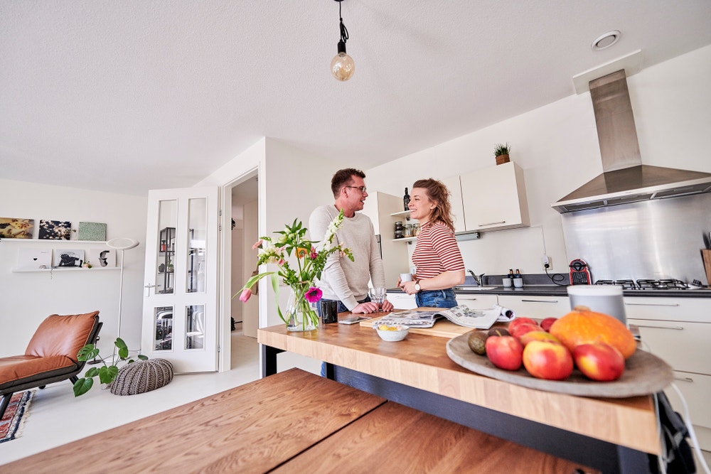 man en vrouw staan aan keukentafel