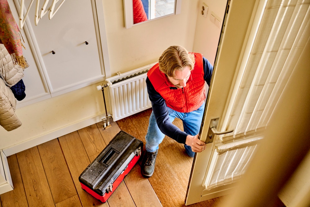 vakman bekijkt voordeur