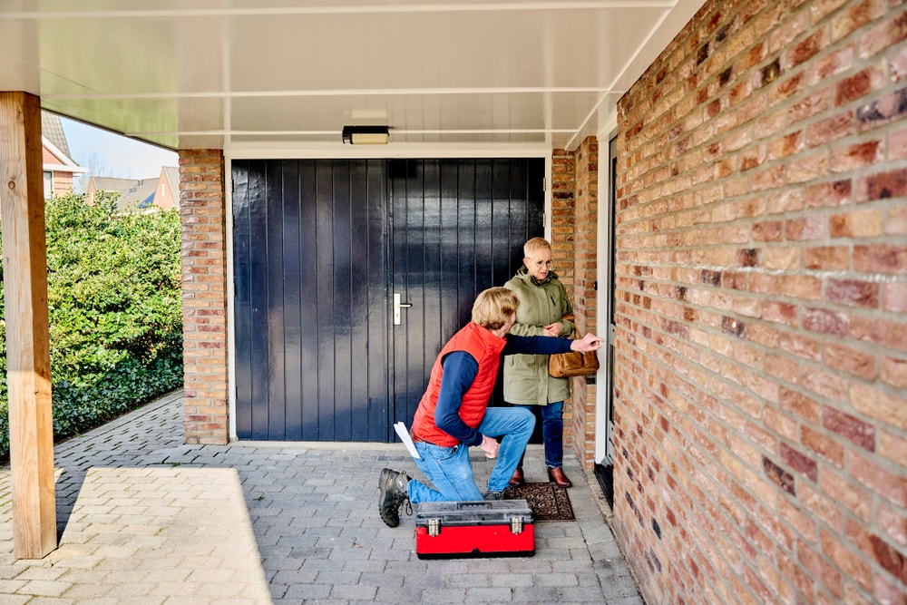 klusjesman bekijkt voordeur met vrouw