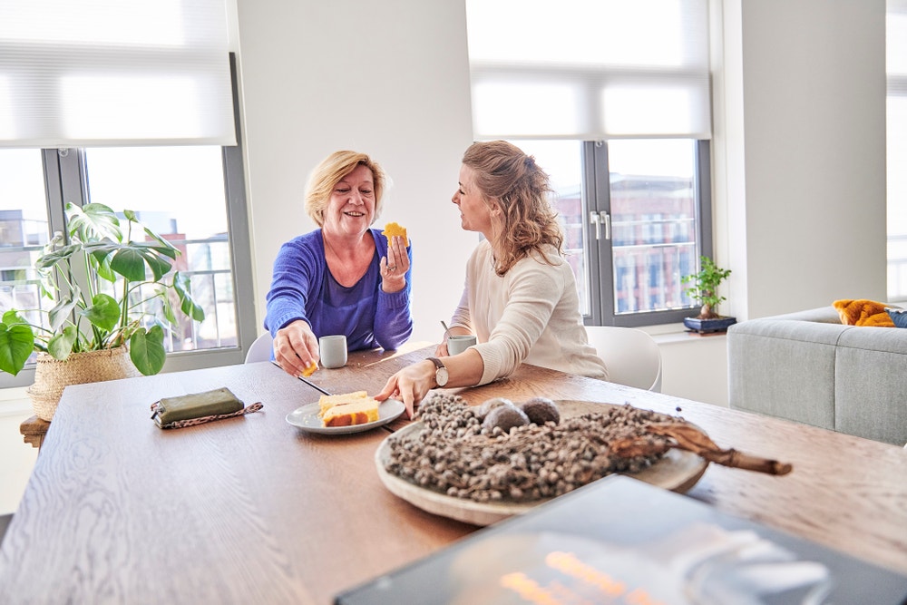 vrouwen drinken koffie met gebak aan tafel