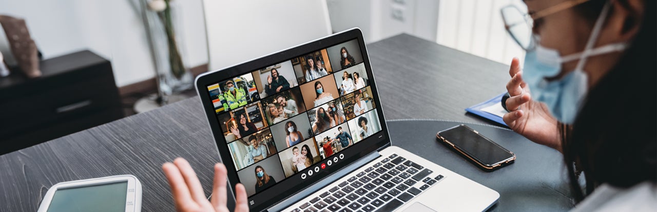 Frau sitzt vor einem laptop während eines Webinars
