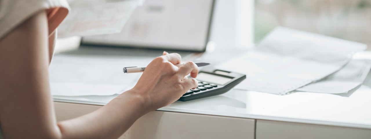 Femme tapant sur une calculatrice