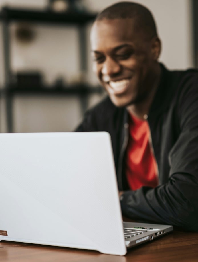 guy smiling while using his laptop