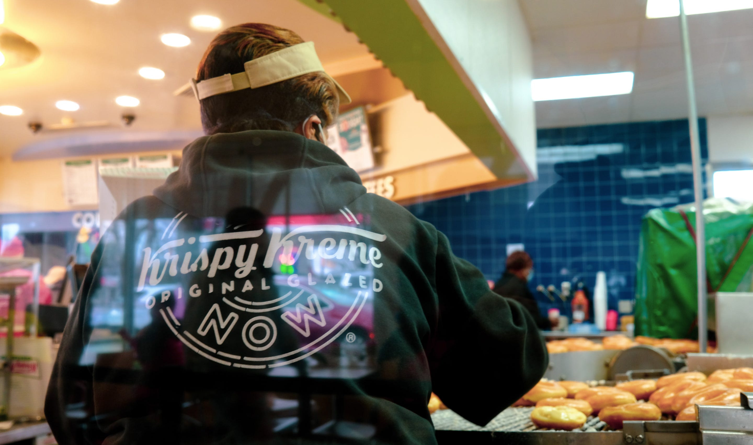 Lady serving fresh Krispy Kreme doughnuts