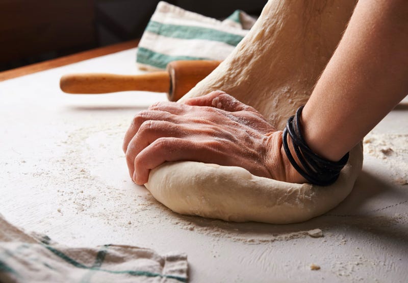 A baker kneading their bread dough