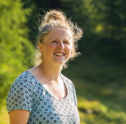 Eine Frau lächelt und schaut in die Kamera.