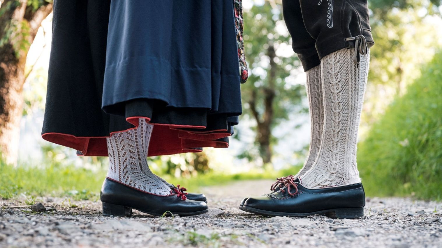 Die Füße eines Mannes und einer Frau in traditioneller Kleidung und Strümpfen.