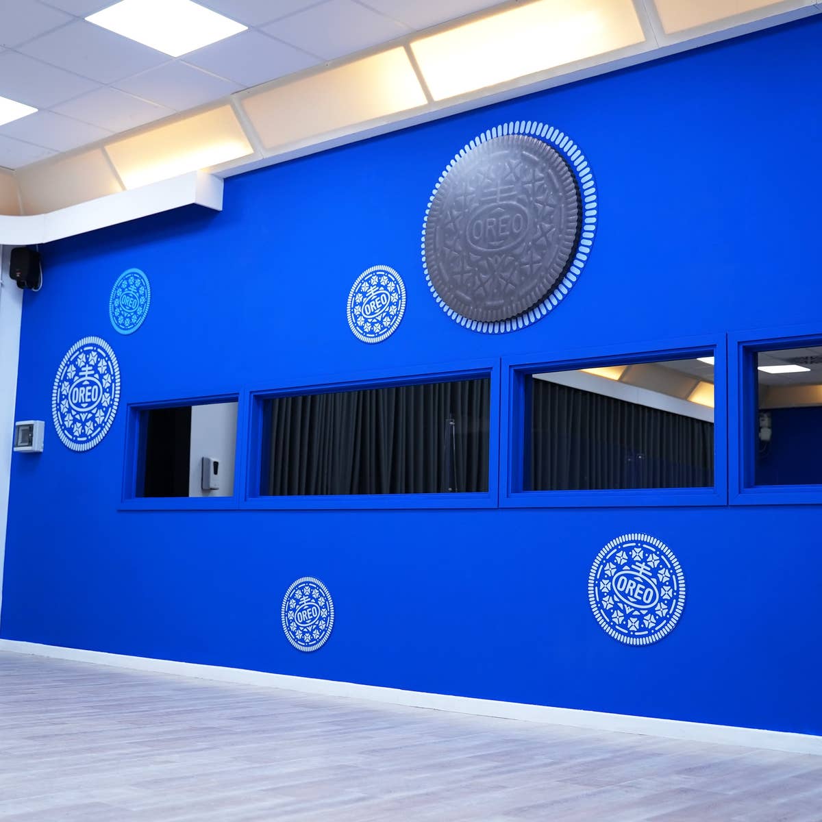 A blue wall with white round Oreo motifs across it