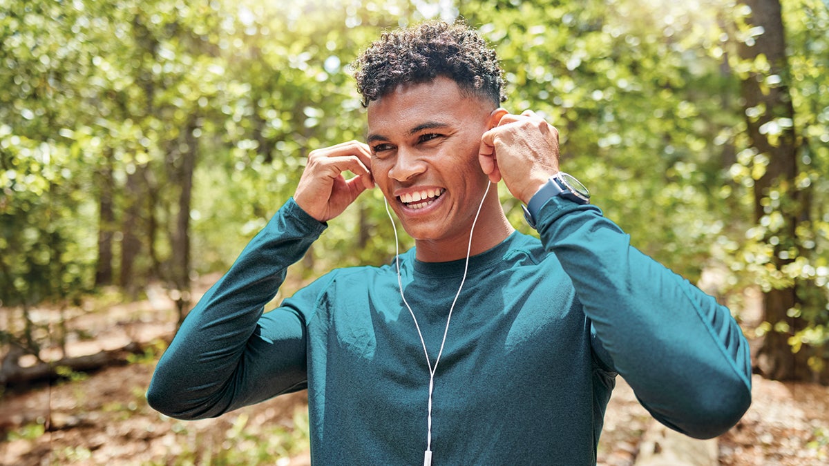 A man wearing earphones and smiling