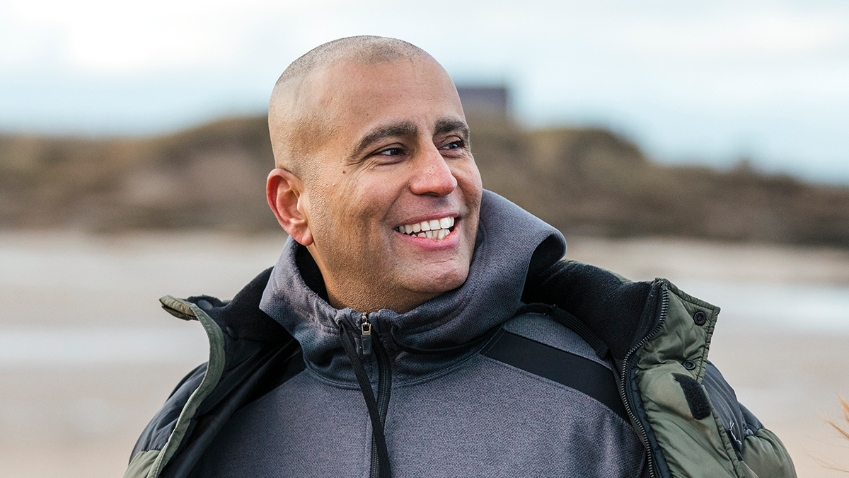 Man outdoors looking to the side smiling