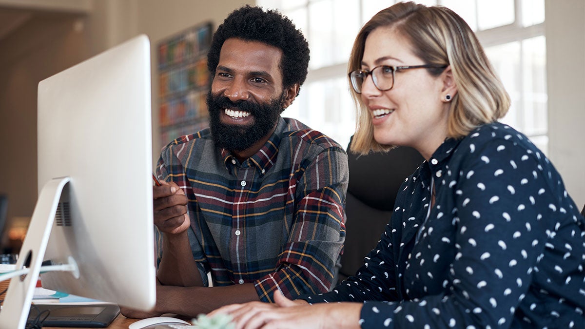 A man and woman looking at a computer screen