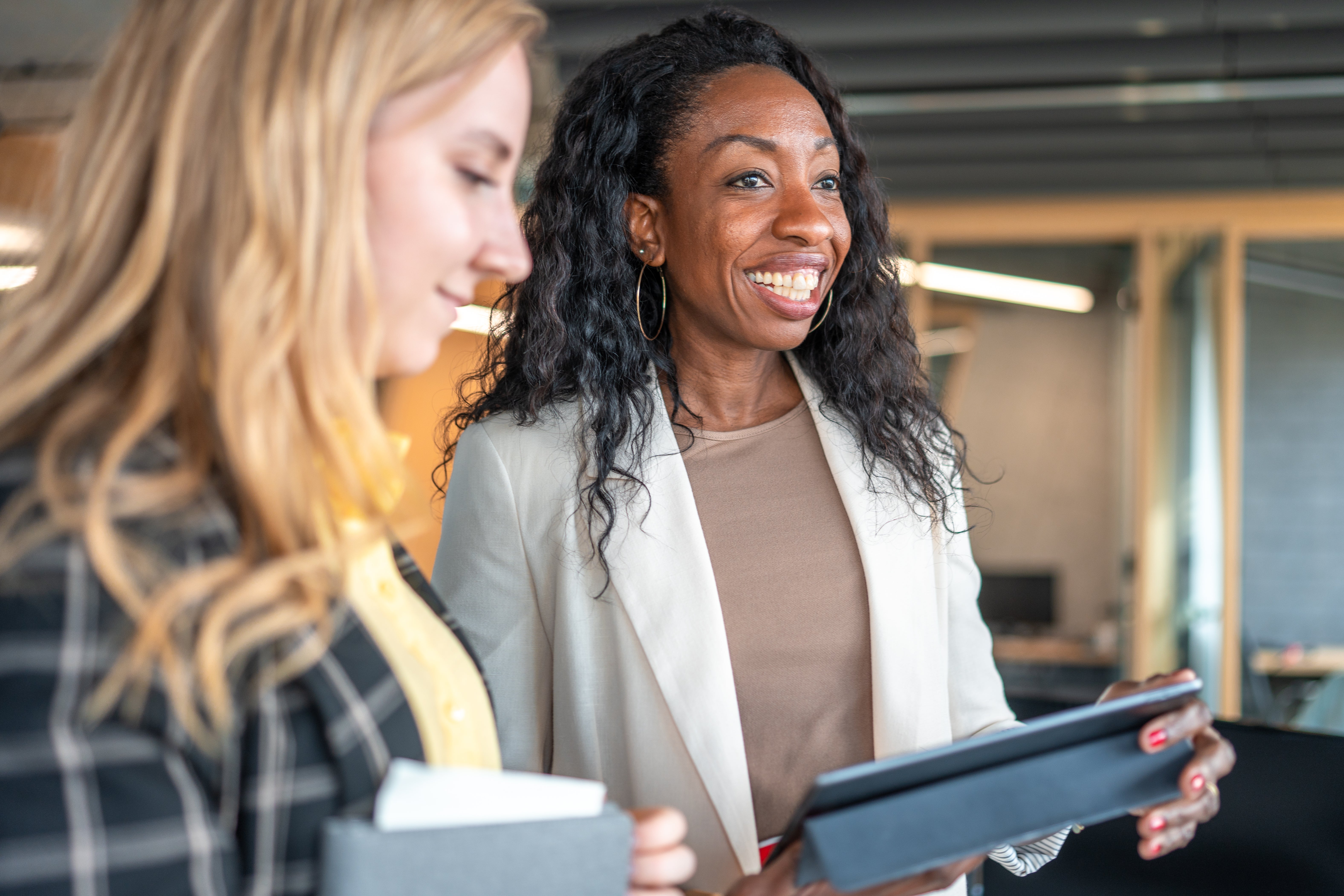 A woman smiling while holding a tablet