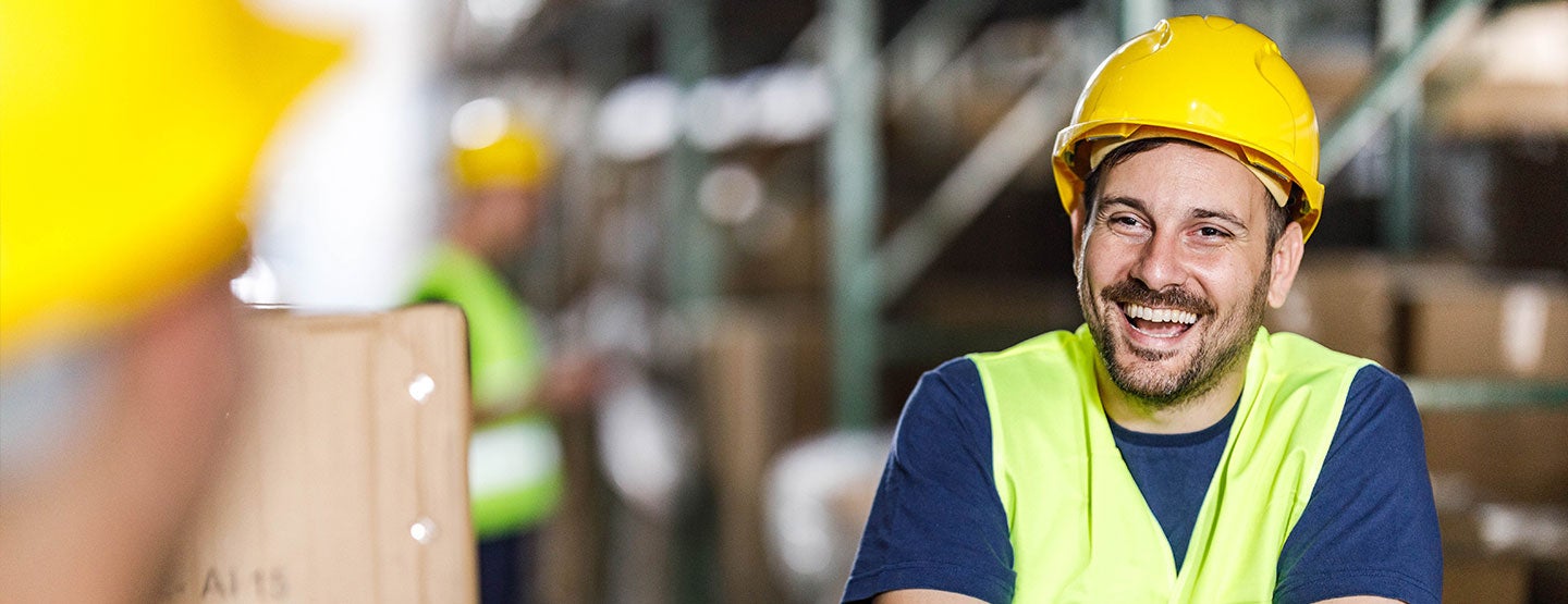 Man in a warehouse smiling to his colleague