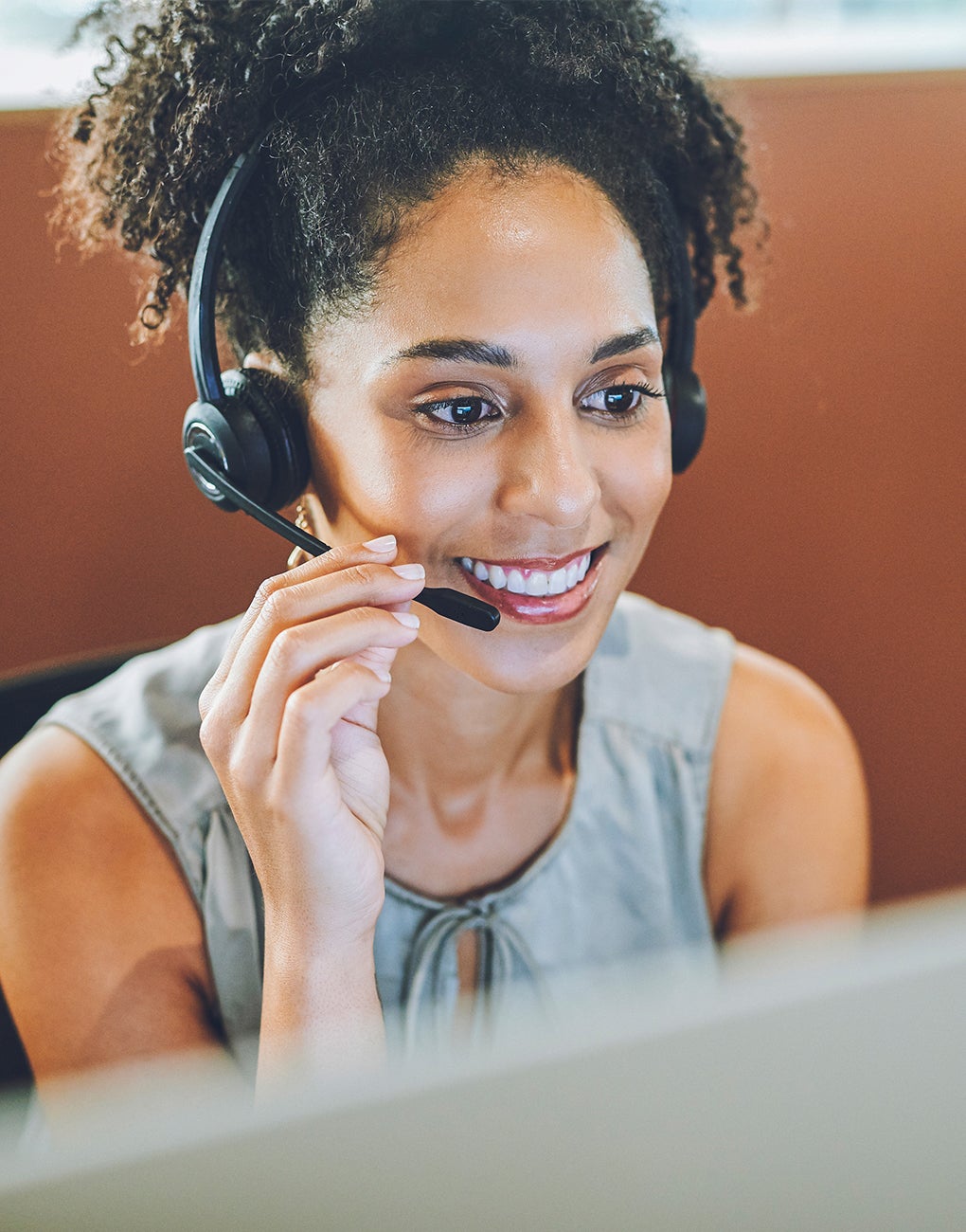 A woman talking to a person over the phone in a headset.